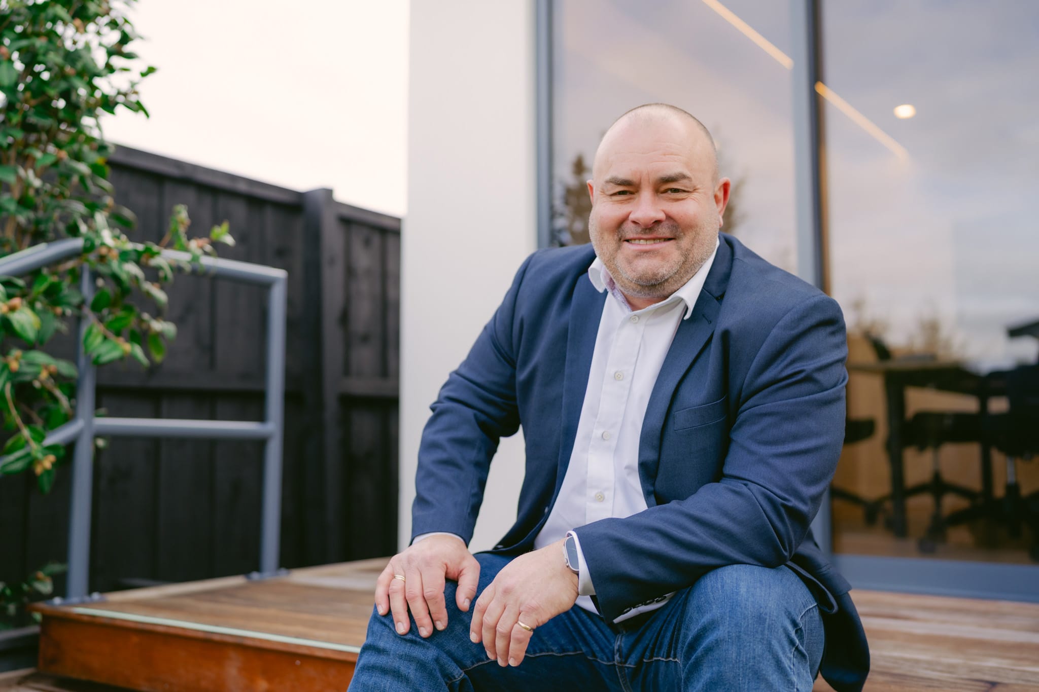Aaron Smith seated outside an office, supporting strong leadership skills, team leadership, and board governance solutions.